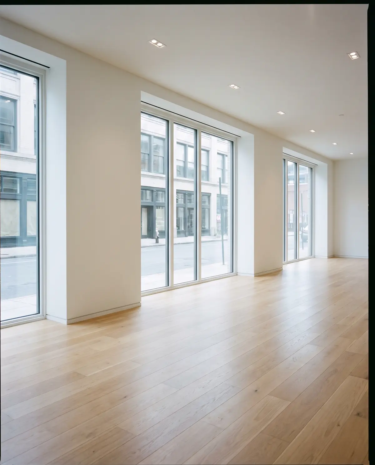 A newly finished commercial space with white walls, clean windows and a dust-free oak floor